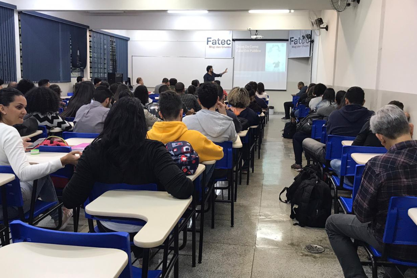 Imagem mostrando palestrante e alunos na palestra.