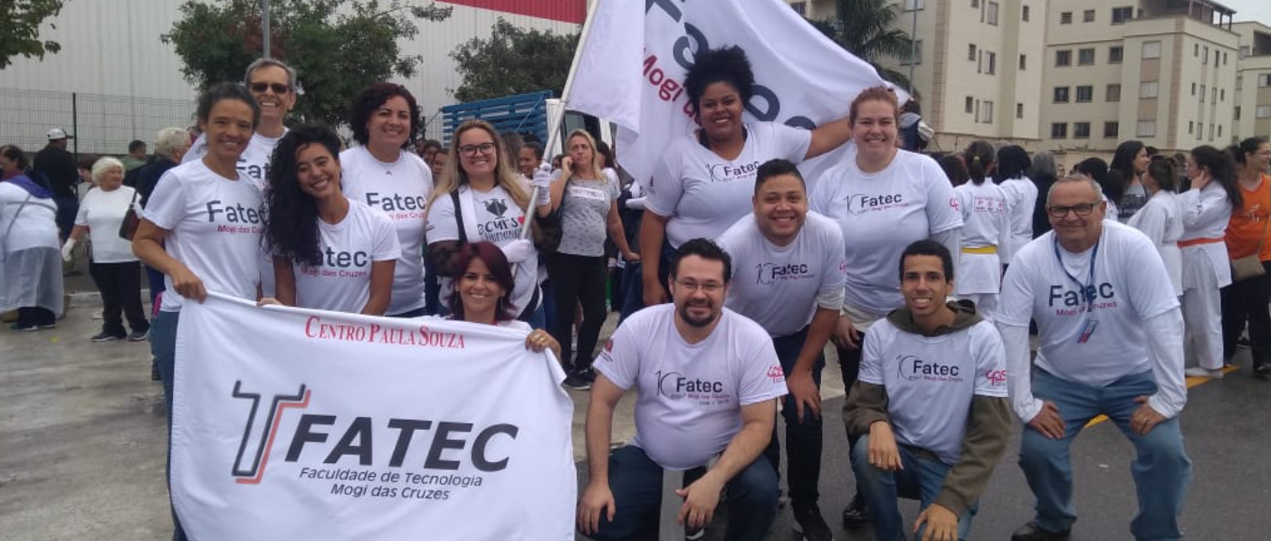 Imagem mostrando professores e alunos no desfile cívico da cidade.